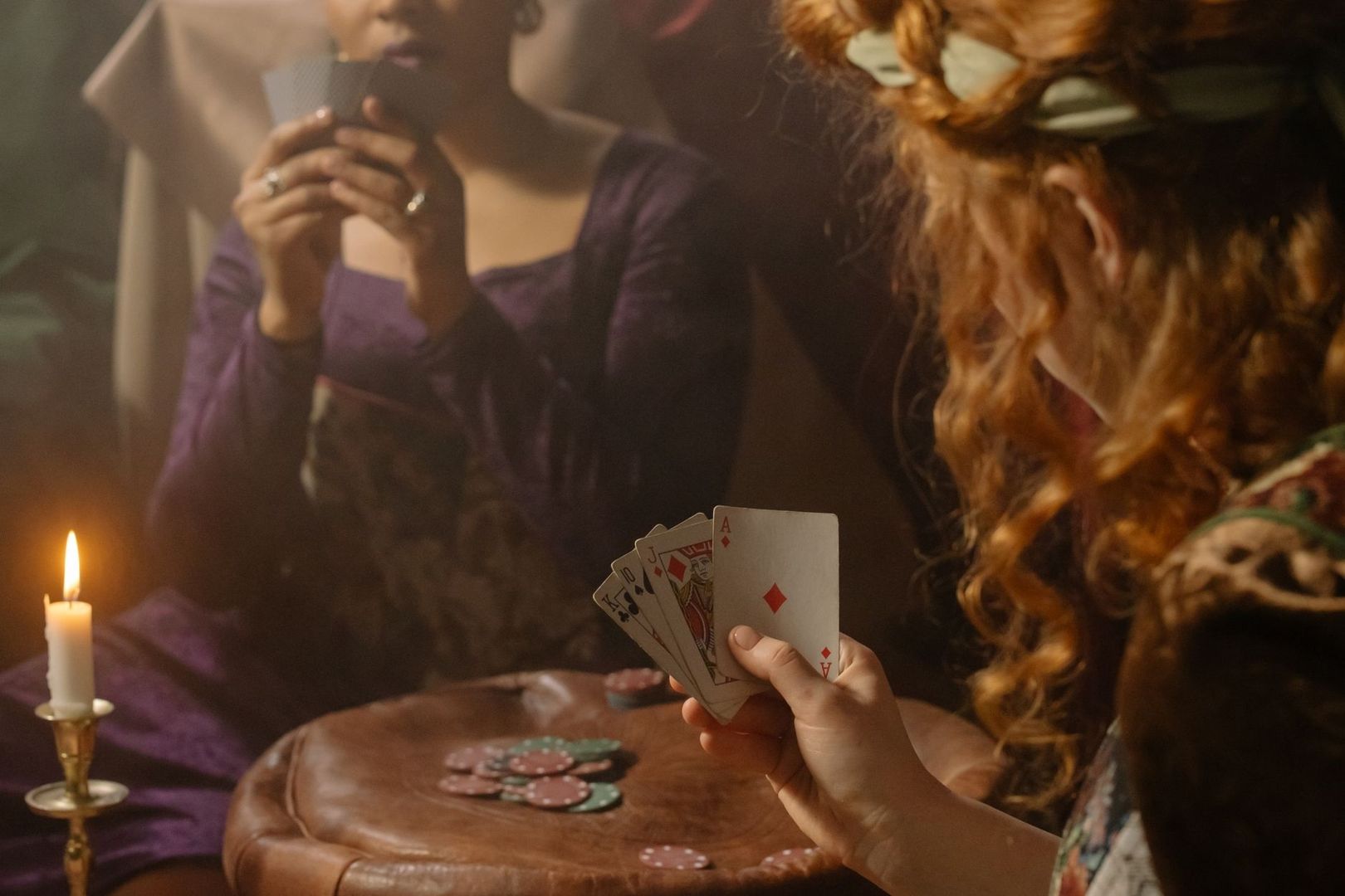 Personer spelar kort och pokerspel vid ett levande ljus