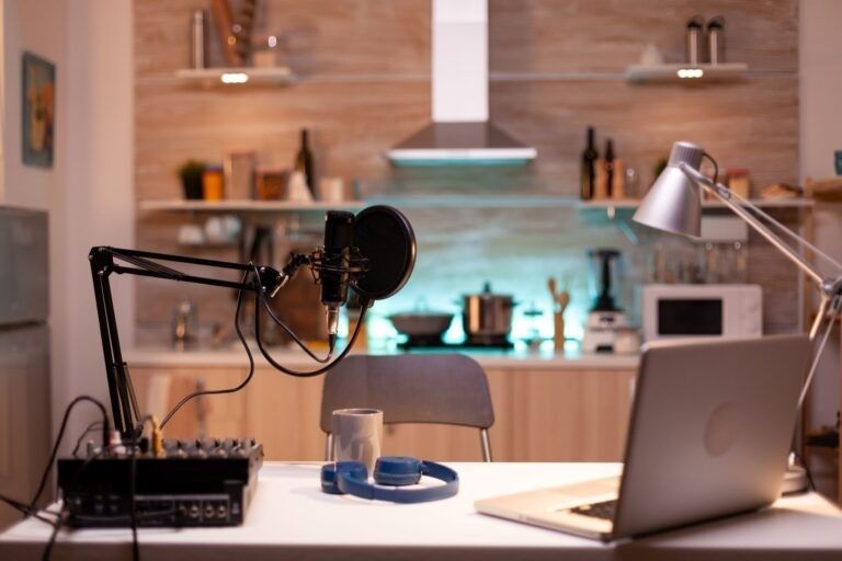 Mikrofon, mixerbord och laptop i hemmastudio för podcast